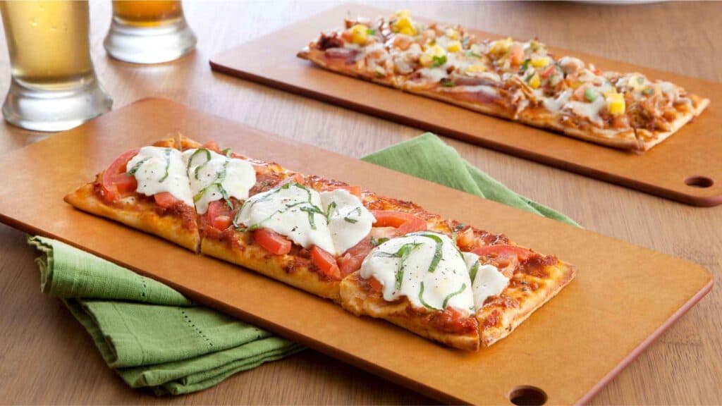 flatbread-pizza-topped-with-tomato-sauce-cheese-and-various-toppings on a table