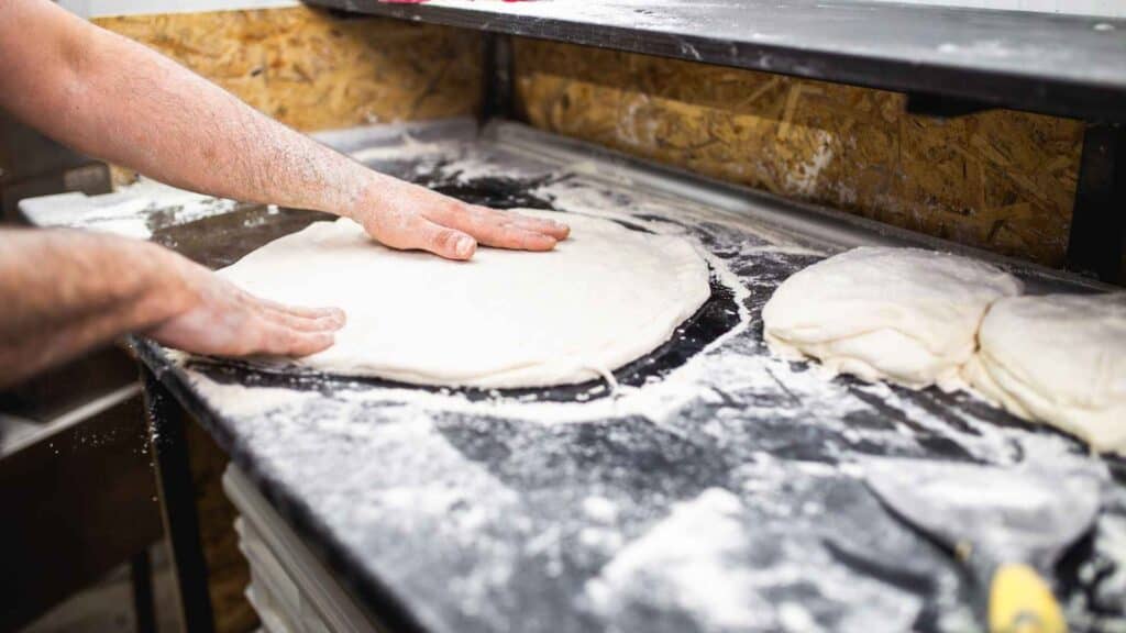 A chef  flating baked flour for pizza