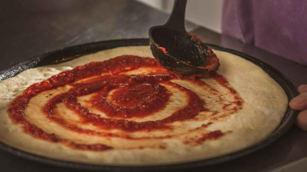 pizza sauce rolled on pizza 