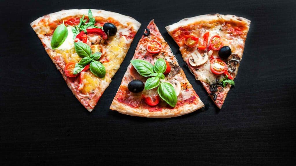 Slices of pizza on black background