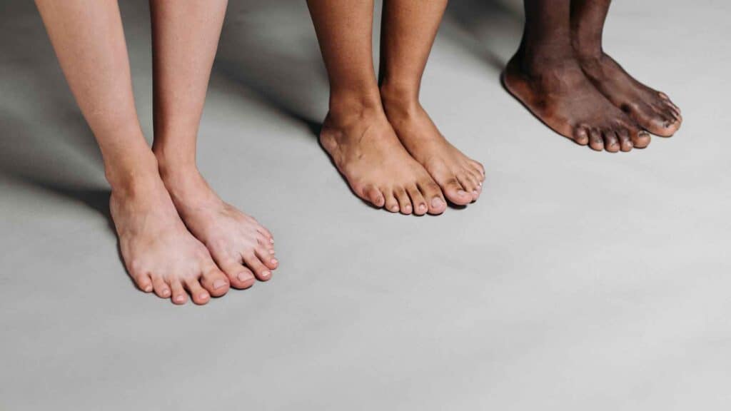 three people standing bare feet