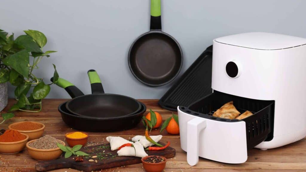 air fryer with frying pan and ingredients in kitchen