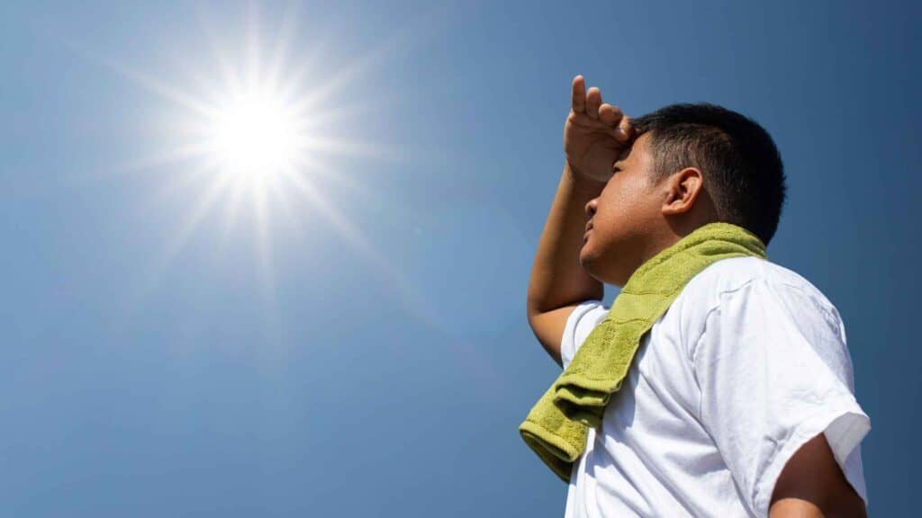 A man putting hand on eyes while looking to sun