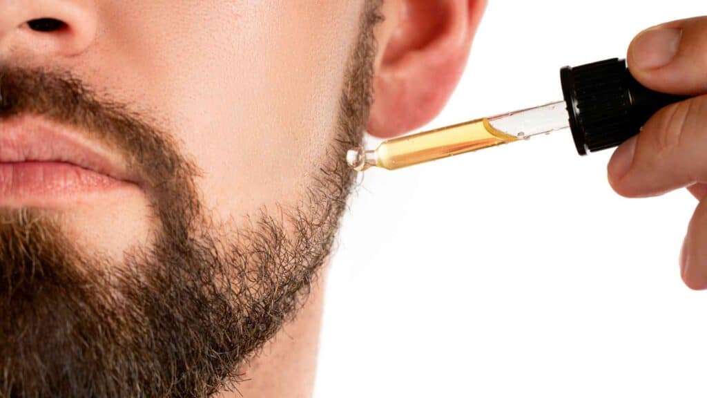 Oil dropper on man's face with beard