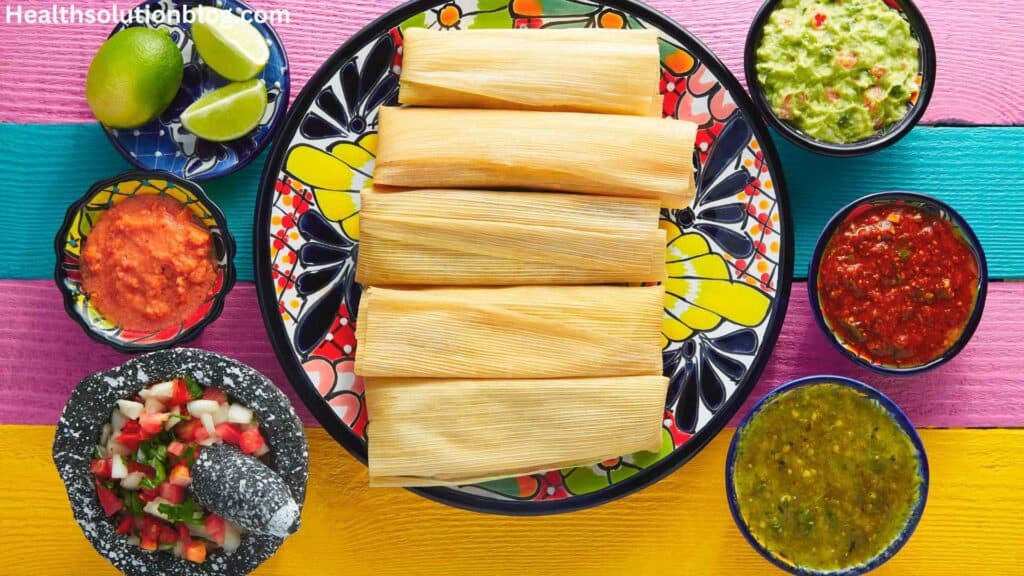 A plate of tamales with sauces