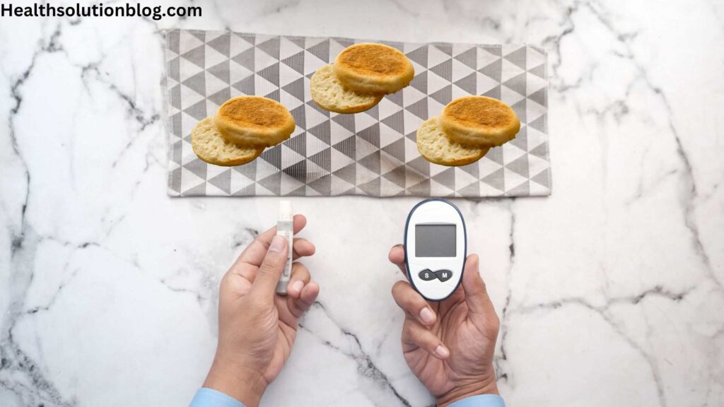 A man wiith glucose monitor and lacet in hands with english muffins in front
