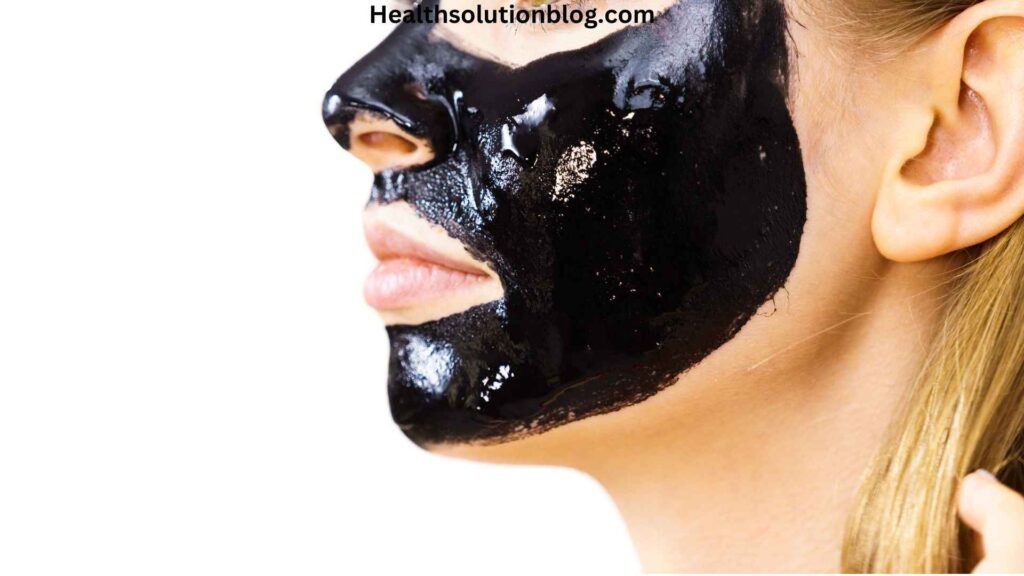 A girl with charcoal peel of face mask on face