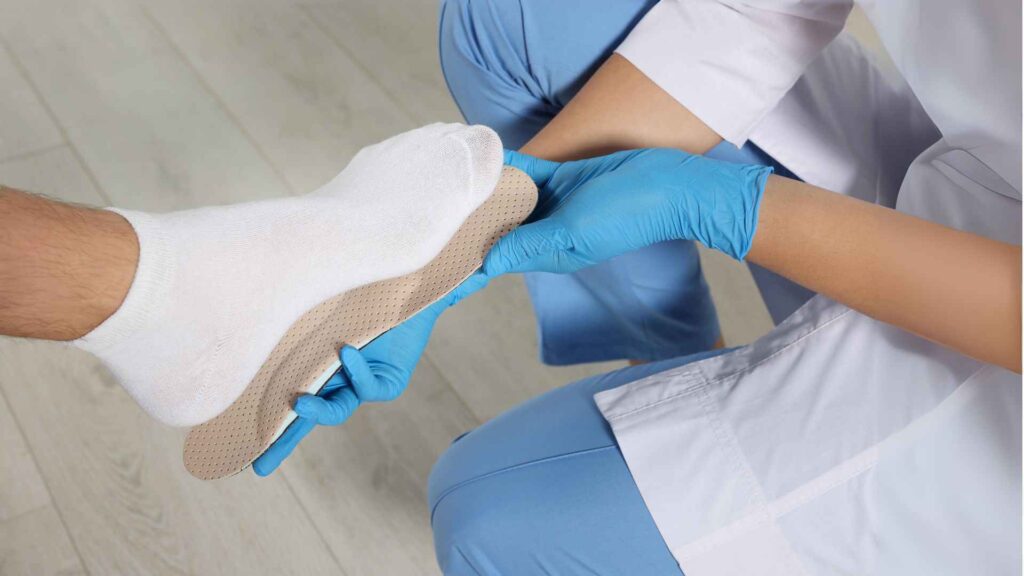 A doctor fitting orthotic insole to patient foot